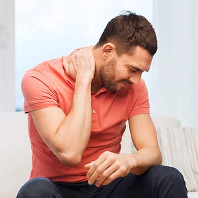 Man holding his neck because he is experience pain that Dr. Fish can help with - contact us